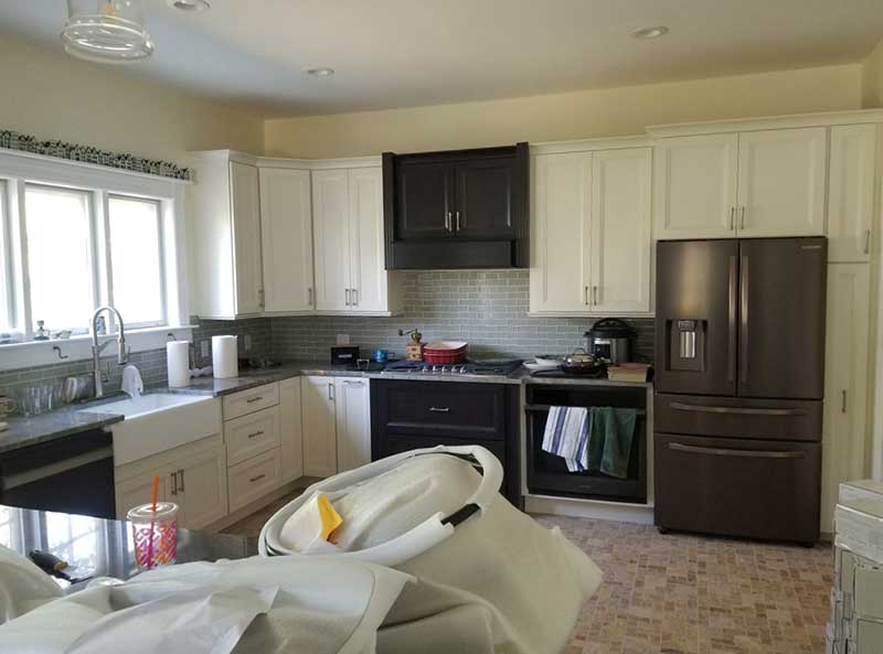Another kitchen with a country style sink has black stainless steel appliances.